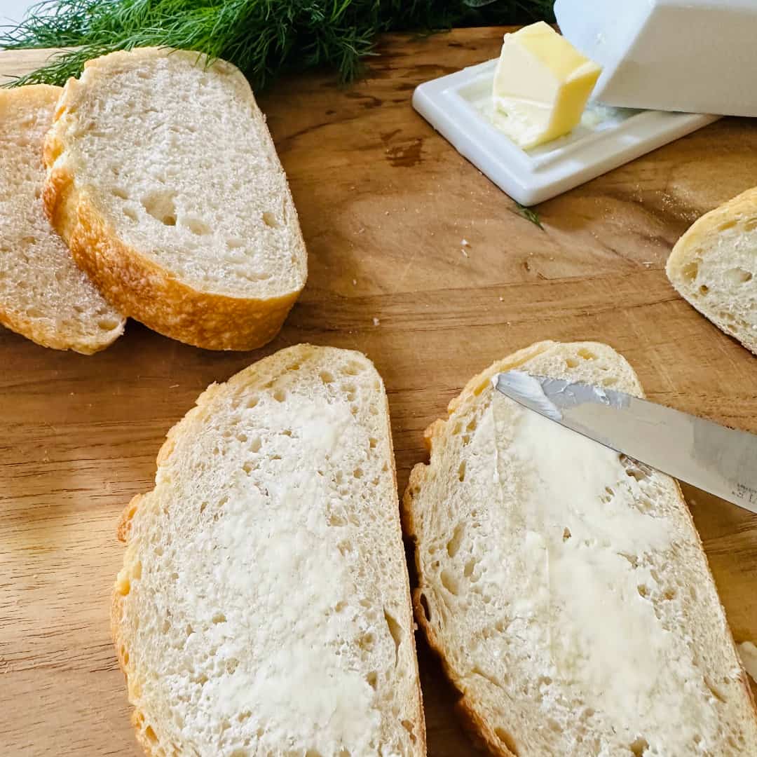 Buttering sourdough slices for smoked salmon toast