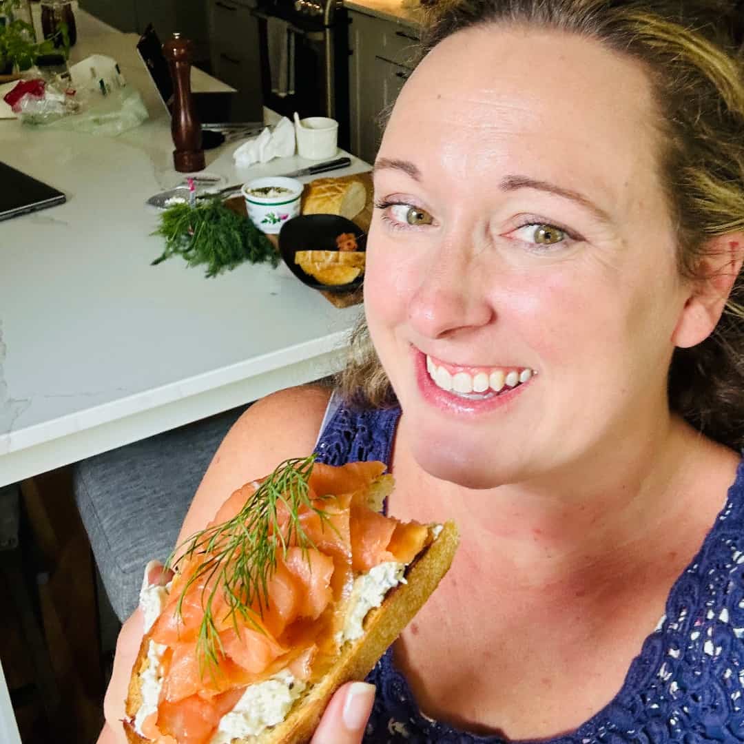 Layering cold-smoked salmon and fresh dill on Alouette toast