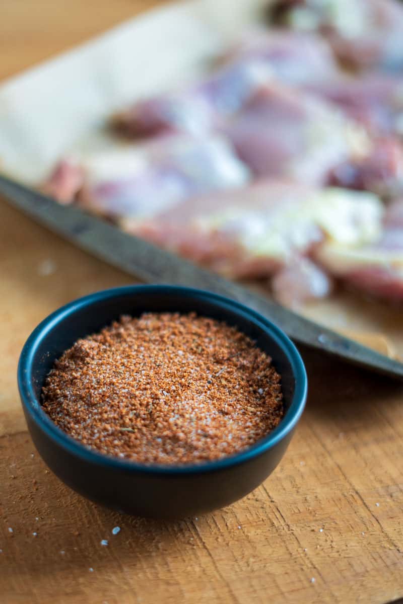 Ingredients for smoked chicken thighs including paprika, garlic powder, and kosher salt