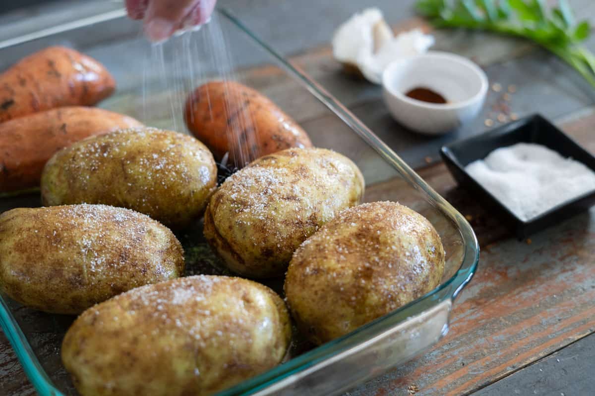 Seasoning russet potatoes with kosher salt before smoking at 225°F