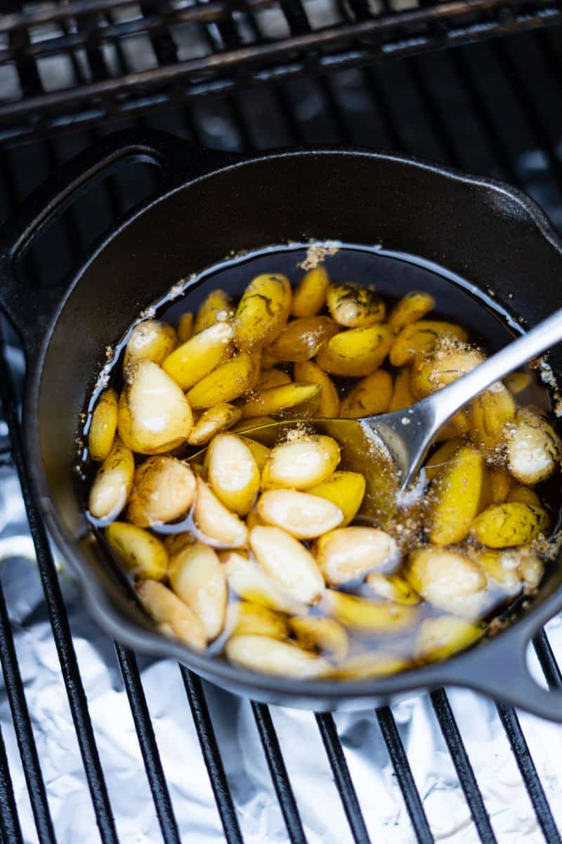 stirring smoked garlic cooking in a cast iron pot