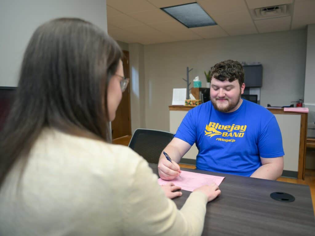 Student working to sign agreement with Tabor representative