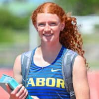 Julianna Maxfield is pictured on the Tabor College track to highlight her athletic and academic success while also wearing a backpack