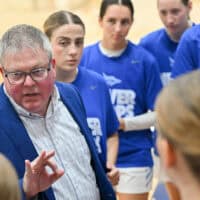 Tabor coach Shawn Reed instructs his player during a timeout of a women's basketball game