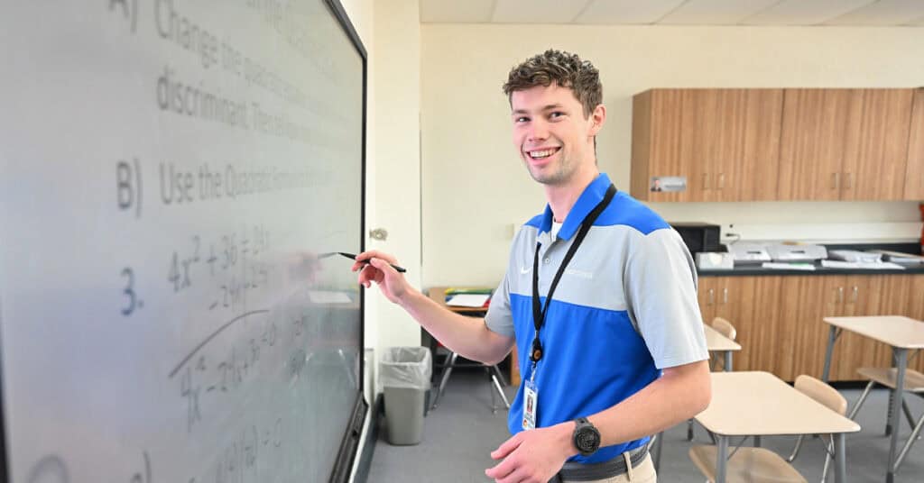 Jacob Goertzen draws equations on a digital whiteboard for his math class
