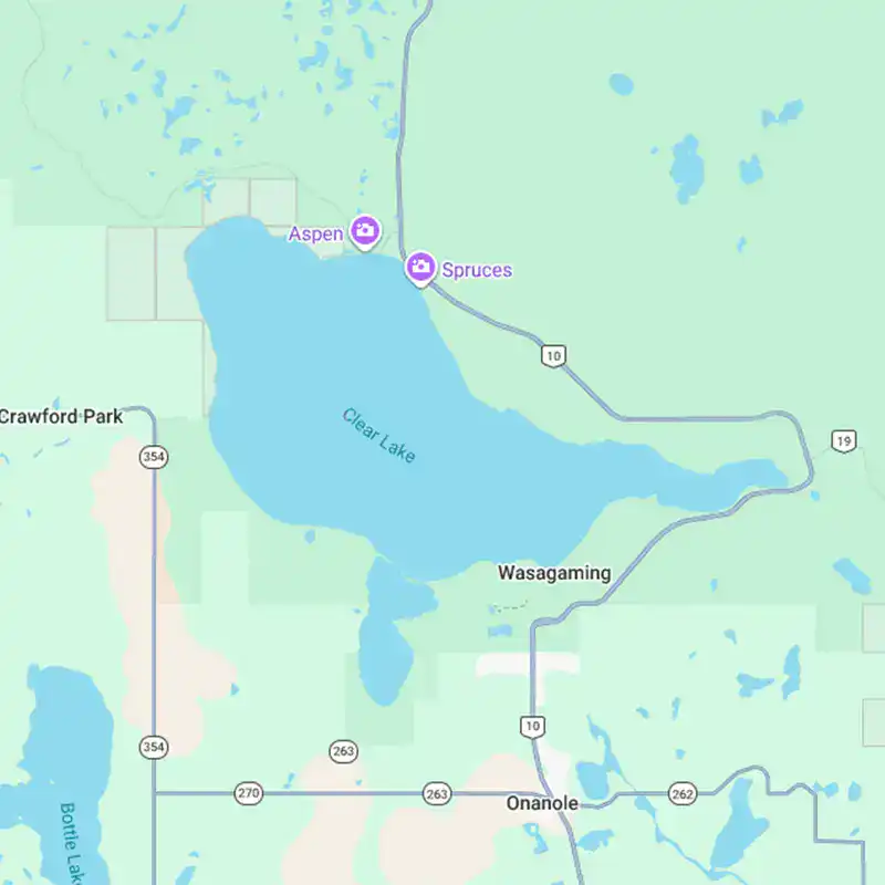 A detailed map of Clear Lake in Manitoba, showing nearby towns Aspen, Spruces, Wasagaming, and Onanole, with roads and surrounding natural features.