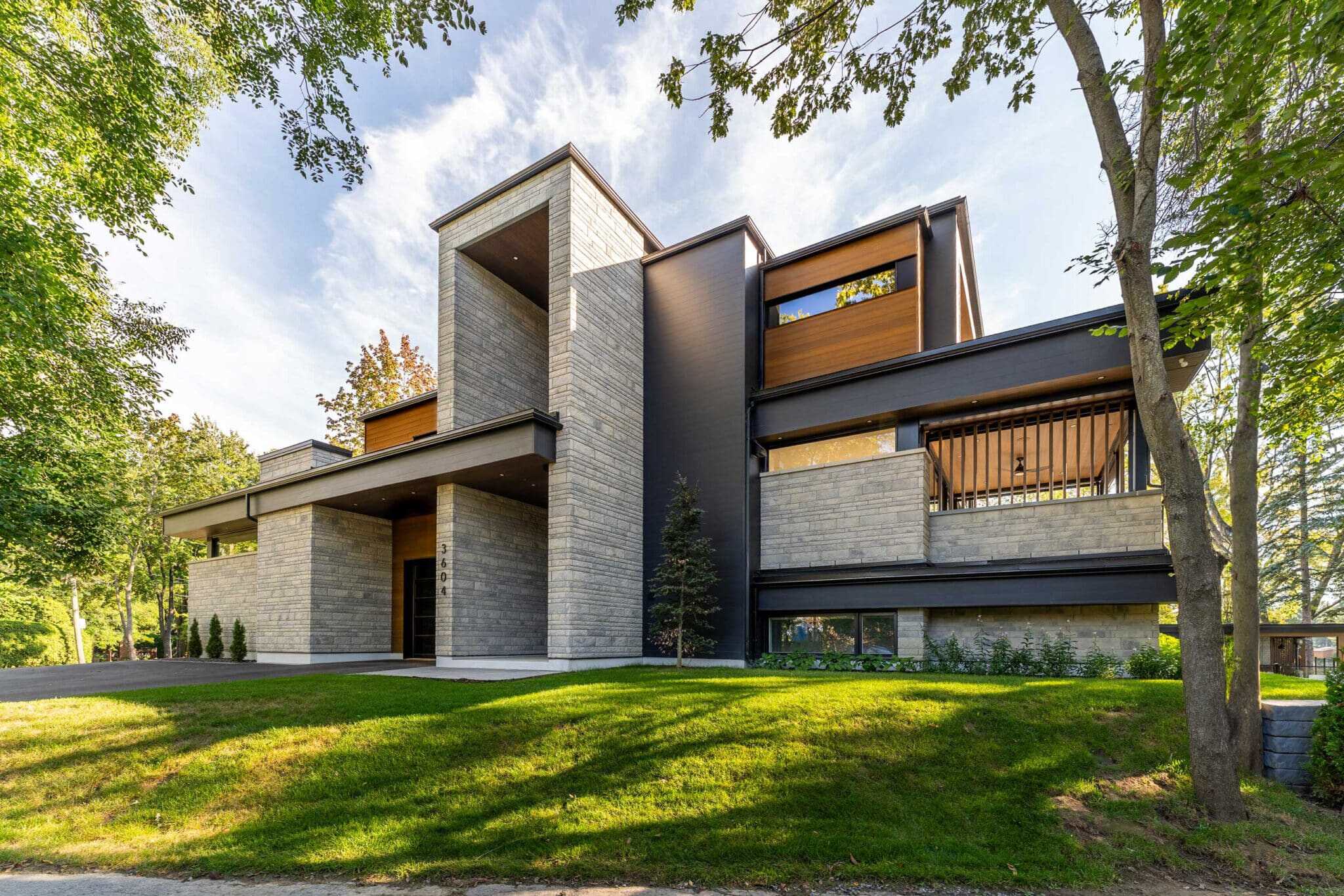 Contemporary modern house with Tamar Building Products exterior in a lush green setting.