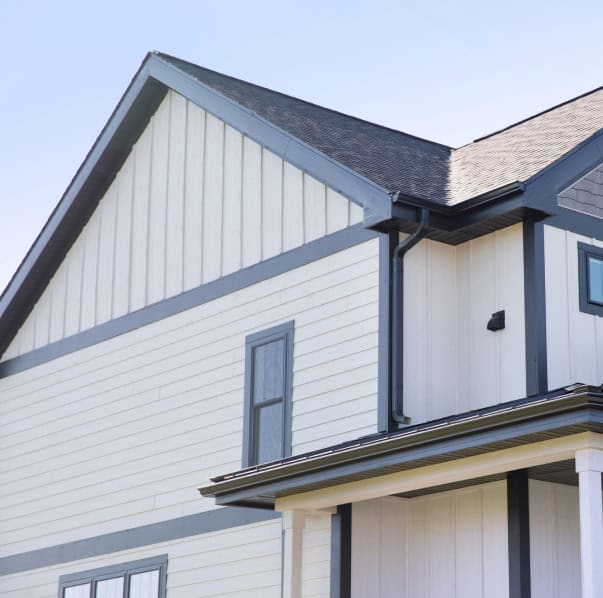 Contemporary white house with blue trim, gable roof, and modern siding design.