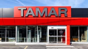 TAMAR Building Products storefront with bold red signage and glass entrance in a commercial area.