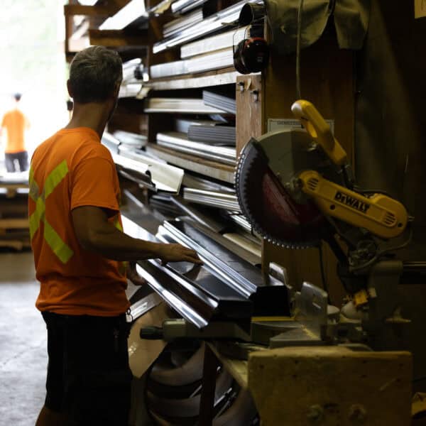 Worker selecting metal building materials in a hardware store.