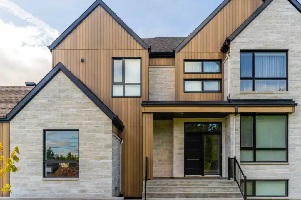 Modern residential building with mixed wood and stone exterior, featuring large windows and a front.