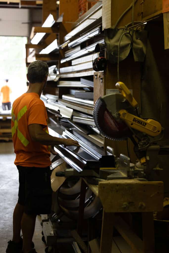 Worker selecting metal building materials in a hardware store.