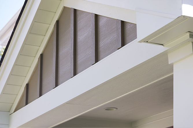 Modern exterior building trim with wood siding and white accents.