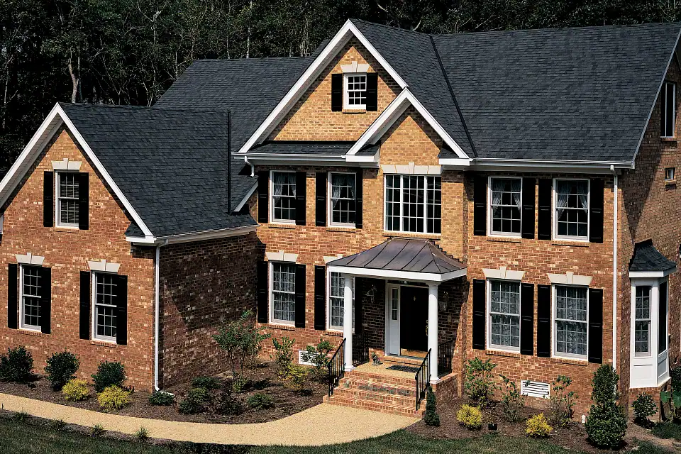 Modern brick house with black roofing and large windows, residential construction in Ontario.