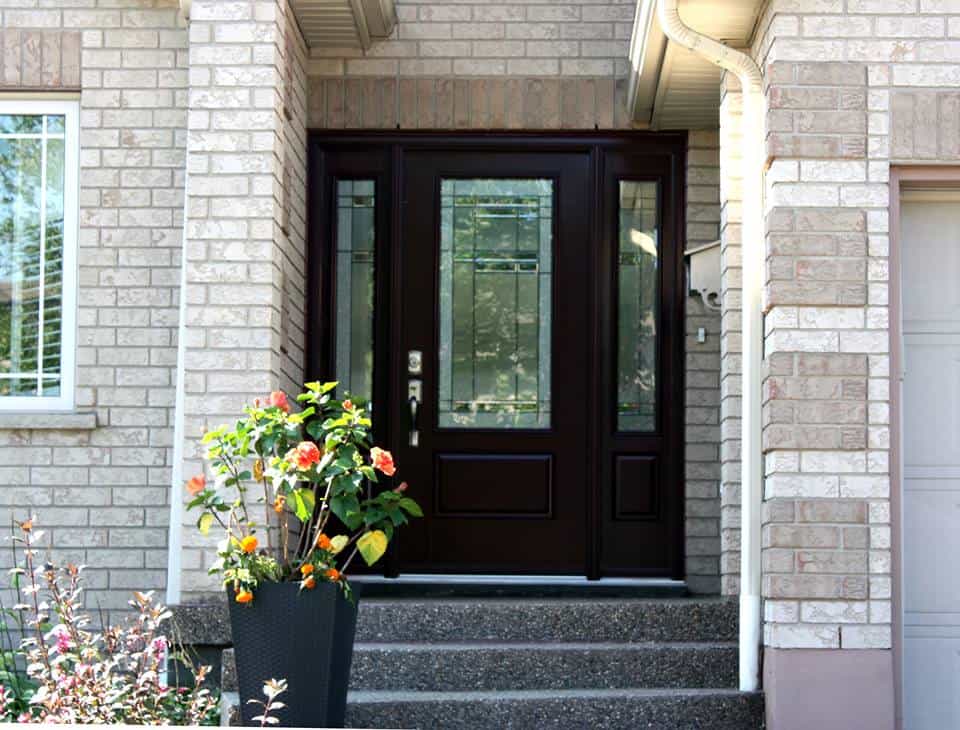Modern black front door with glass panel, set in a brick house exterior. Perfect for enhancing curb.