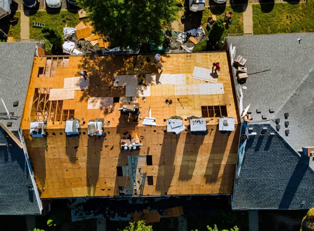 New wooden roof construction on residential building in progress, aerial view.