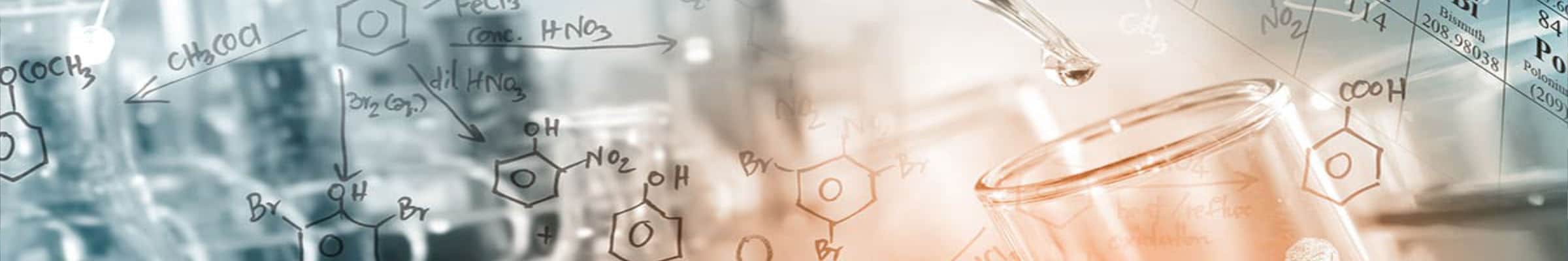 Chemical formulas written on a glass pane with a blurry background of a laboratory setting featuring flasks and pipettes.