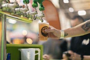 Golden craft beer being poured from tap at Taranaki Beer Festival in New Zealand.