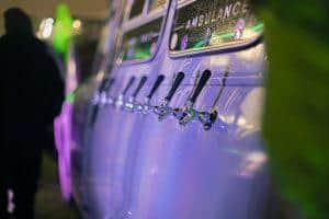 Cold beer taps at Taranaki Beer Festival, New Zealand, with vibrant neon lighting and festive atmosphere.