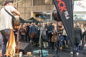 Crowd enjoying live music at Taranaki Beer Festival in an indoor venue with beer tents.