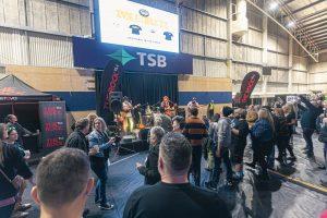 Vibrant crowd enjoying live music at Taranaki Beer Festival with brewery tents and entertainment.