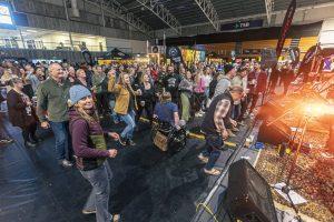 Vibrant crowd enjoying live music and beer at Taranaki Beer Festival indoor venue in New Zealand.