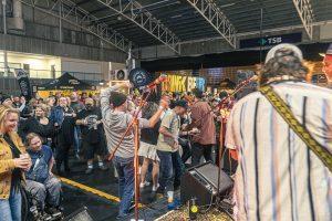 Crowd enjoying live music at Taranaki Beer Festival with craft beers and festival atmosphere.
