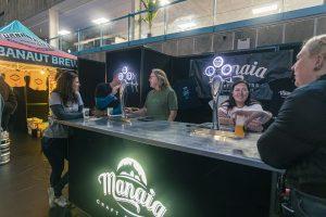 Vibrant scene at the Taranaki Beer Festival showcasing craft beers and brewers enjoying a lively atmosphere.