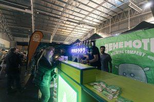 Bright indoor at Taranaki Beer Festival showcasing craft beer stalls and beer enthusiasts.