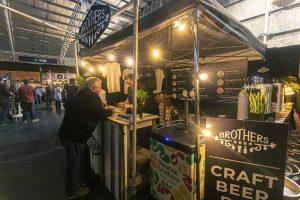 Vibrant Taranaki Beer Festival stall showcasing craft beers and outdoor event atmosphere.