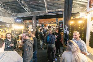 Craft beer tasting at Taranaki Beer Festival with local breweries and lively crowd.