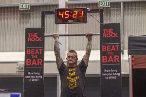 Powerlifter hanging from a bar at Taranaki Beer Festival.