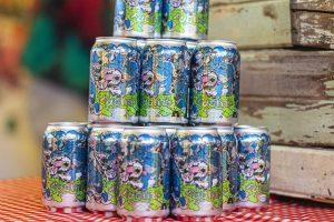 Vivid cans of fuzzy unicorn beer featuring colorful, cartoon-style dragon design at Taranaki Beer Festival.
