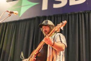 Live musician playing acoustic guitar at Taranaki Beer Festival, enjoying craft beers and local entertainment in New Zealand.