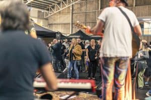 Vibrant crowd enjoying live music and craft beer at Taranaki Beer Festival in an indoor venue.