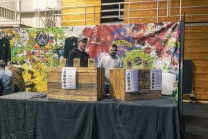 Vibrant craft beer stall at Taranaki Beer Festival with two brewers showcasing locally brewed beers in New Zealand.