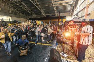 Vibrant scene at Taranaki Beer Festival with live music, craft beers, and enthusiastic crowd enjoying the event.