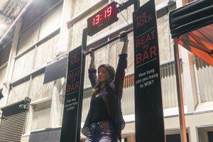 Vibrant woman hanging from a bar at the Taranaki Beer Festival in New Zealand.