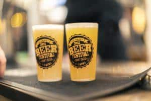 Golden craft beer glasses with "Taranaki Beer Festival 2022" logo, celebrating local beer events in Taranaki.