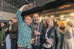 Festive crowd enjoying Taranaki Beer Festival with craft beers from Roots Brewing.