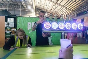 Bright beer festival scene at Taranaki Beer Festival showcasing craft beer taps and enthusiastic attendees.