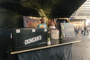 Vibrant Taranaki Beer Festival stall with diverse craft beers, lively atmosphere, and artistic decor at the popular Taranaki Beer Festival, New Zealand.