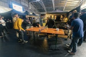 Vibrant scene at the Taranaki Beer Festival with attendees enjoying craft beers and social games in an indoor venue.