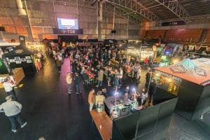 Festive indoor Taranaki Beer Festival with craft beers, live music, and food stalls in a large event hall.