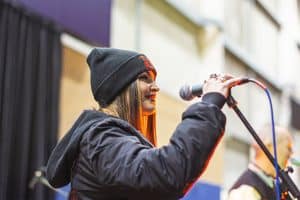 Vibrant female singer performing at the Taranaki Beer Festival in New Zealand, with lively atmosphere and local craft beers.