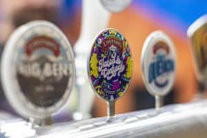 Colorful craft beer tap handle featuring "Hazard & Confused" IPA at Taranaki Beer Festival.