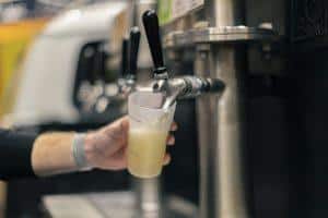 Golden beer being poured from a tap at Taranaki Beer Festival, showcasing craft beer and brewery experiences.