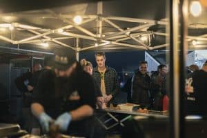 Craft beer festival in Taranaki with people enjoying local brews at night.