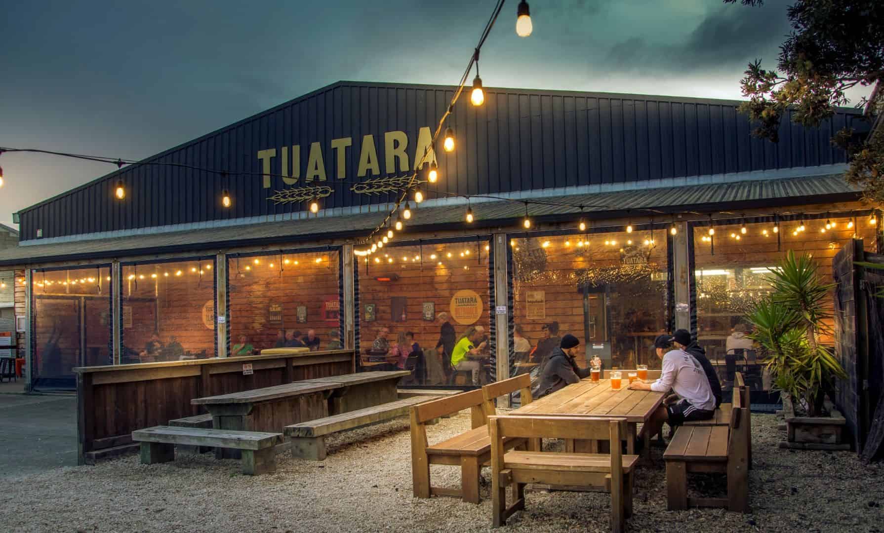 Vibrant Taranaki Beer Festival outdoor venue with patrons enjoying craft beer under string lights.