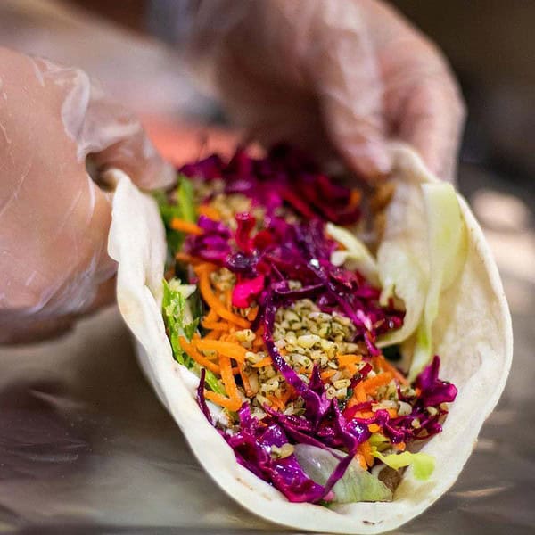 Fresh vegetable wrap with colourful shredded carrots, purple cabbage, and seeds, served at Taranaki Beer Festival.